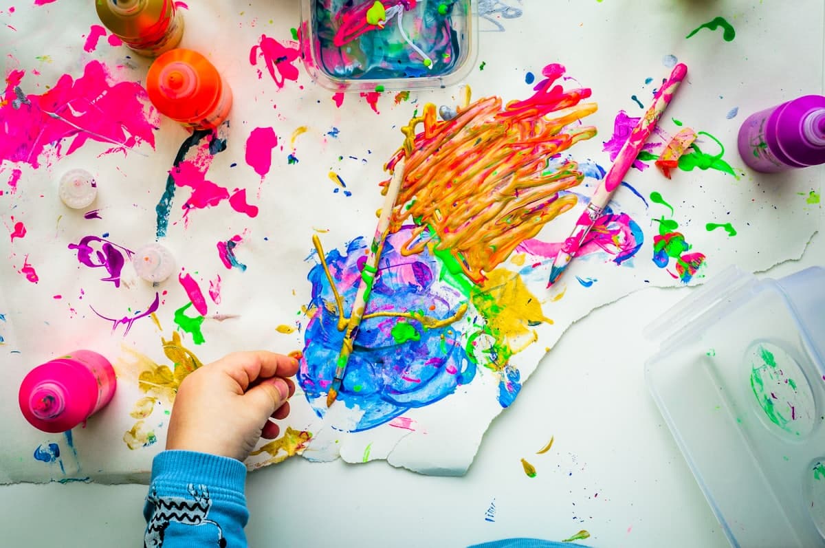 يد طفل ترسم بألوان زاهية