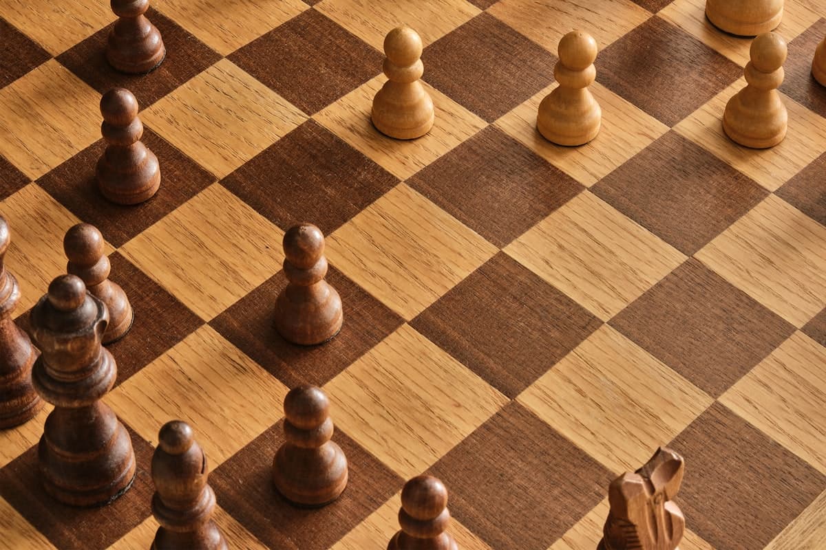 رقعة شطرنج خشبية عليها البيادق في وضع البداية