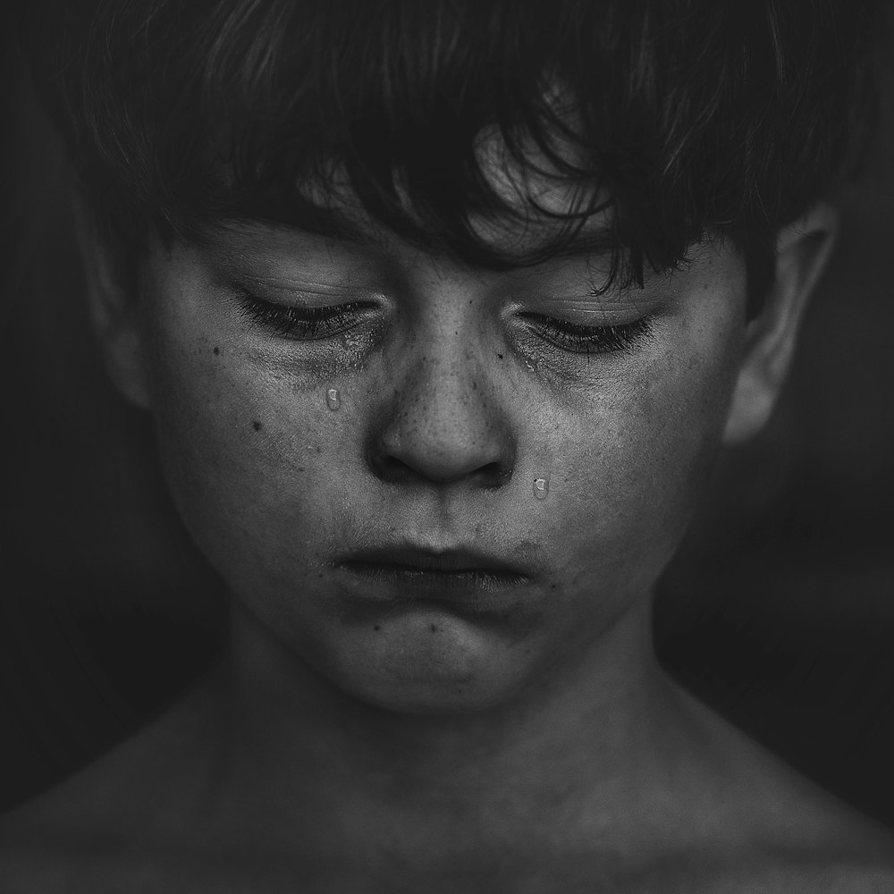 صورة بالأبيض والأسود لطفل حزين
